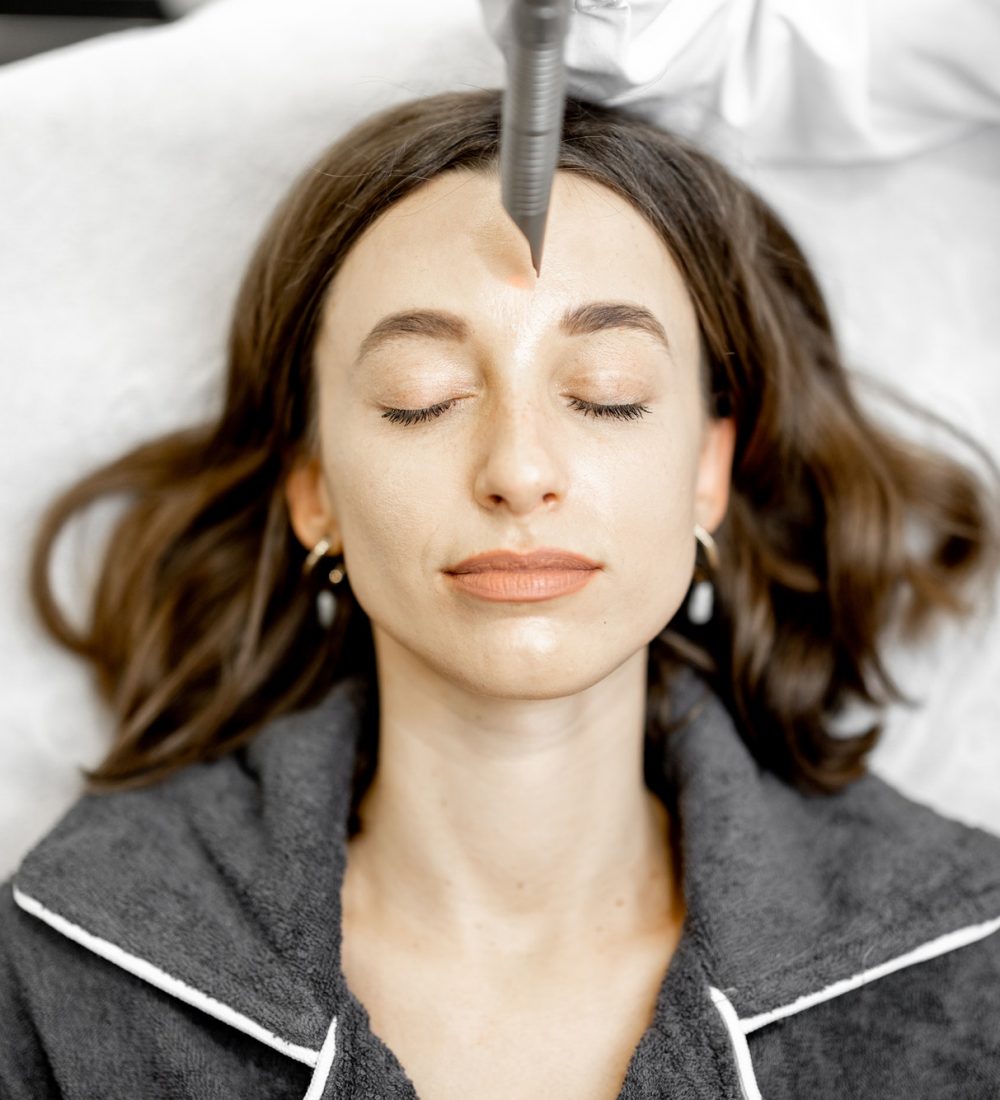 cosmetóloga haciendo un procedimiento de lifting facial con láser en una clínica de belleza.jpg