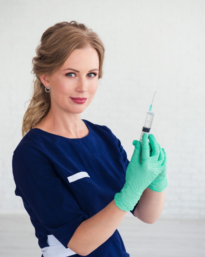 jeune femme-cosmetologue-en-uniforme-bleu-tenant-une-seringue-une-injection-de-beauté.jpg